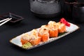 Close up of assorted baked sushi set with salmon, shrimp, caviar, mussels, tuna, cream cheese and hot sauce and Royalty Free Stock Photo