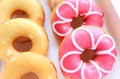 Close up of assorted glazed sweet donuts in a paper box . Royalty Free Stock Photo