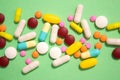 Close up of assorted multicolored medicine pills, capsules and tablets on green background. Immune system vitamins and Royalty Free Stock Photo