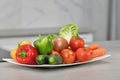 View of an assortment of fresh vegetables on a plate on an out of focus background. Fresh food and vegetables concept Royalty Free Stock Photo