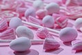 Close up of assortment of pink and white candies on pink background with selective focus