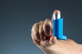 Close-up with an asthma inhaler in a male hand, asthmatic attack. The concept of treatment of bronchial asthma, cough, allergies, Royalty Free Stock Photo