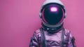 Close up of astronaut in purple headgear with camera on pink background