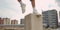 Close-up athlete foots vaulting over urban obstacles in a dynamic action, concept of Parkour, created with Generative AI