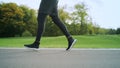 Athlete in sports shoes jogging on road. Man legs training outdoors Royalty Free Stock Photo