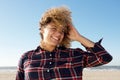 Close up attractive african american woman smiling with hand in hair at the beach Royalty Free Stock Photo