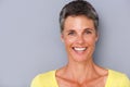 Close up attractive middle age woman smiling against gray background