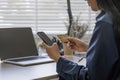 Close up attractive millennia Asian female holding her smartphone and credit card, using mobile banking app or online Royalty Free Stock Photo