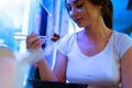 Close up of attractive woman eating asian food with chopsticks at restaurant. Royalty Free Stock Photo