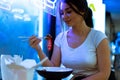 Close up of attractive woman eating asian food with chopsticks at restaurant. Royalty Free Stock Photo