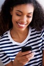 Close up attractive young african american woman looking at cell phone Royalty Free Stock Photo