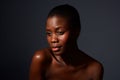 Close up attractive young african woman against gray background with naked shoulders Royalty Free Stock Photo