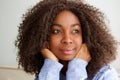 Close up attractive young african woman with curly hair looking away and thinking Royalty Free Stock Photo