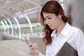 Close up attractive young Asian business woman looking mobile smart phone in her hands at outside office with copy space backgroun Royalty Free Stock Photo