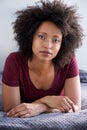 Close up attractive young black woman with curly hair lying on floor at home Royalty Free Stock Photo