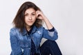 A close-up of attractive young brown-eyed girl wearing jean jacket looking into camera very attentively being confident in herself Royalty Free Stock Photo