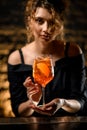 Close-up of attractive young woman at bar holds in her hand glass with cocktail Royalty Free Stock Photo