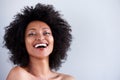 Close up attractive young woman with naked shoulders laughing on gray background Royalty Free Stock Photo