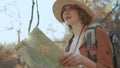 Close up Attractive young woman in stylish hat and a tourist map in her hands looking around Royalty Free Stock Photo