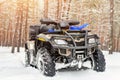 Close-up ATV 4wd quad bike in forest at winter. 4wd all-terreain vehicle stand in heavy snow with deep wheel track. Seasonal Royalty Free Stock Photo