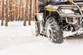 Close-up ATV 4wd quad bike in forest at winter. 4wd all-terreain vehicle stand in heavy snow with deep wheel track. Seasonal Royalty Free Stock Photo
