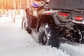 Close-up ATV 4wd quad bike in forest at winter. 4wd all-terreain vehicle stand in heavy snow with deep wheel track. Seasonal Royalty Free Stock Photo