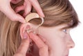 Close up of an Audiologist hands inserting a hearing aid into ea Royalty Free Stock Photo