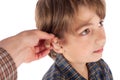 Close up of an Audiologist`s hand fitting hearing aid to a young boy Royalty Free Stock Photo