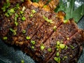 Close-up Australian sliced medium rare wagyu grilled beef steak top with sliced spring onion on glass plate on dark background. Royalty Free Stock Photo