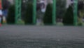 Close up aut focus of men`s feet playing and running through football field in the city park. Shallow depth of the field