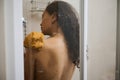 Close-up authentic portrait of a beautiful woman taking shower in her bathroom. View from the back of attractive naked Royalty Free Stock Photo