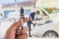 Close up auto mechanic holds a spare part spark plug in his hand. repair the car. Royalty Free Stock Photo