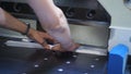 Close-up of automated paper cutting machine. Stock footage. Modern machine with straight blade for cutting large stacks