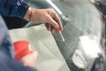 Close up Automobile glazier worker fixing and repair windscreen or windshield of a car in auto service station garage Royalty Free Stock Photo