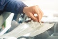 Close up Automobile glazier worker fixing and repair windscreen or windshield of a car in auto service station garage