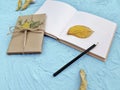 Close up autumn minimalist composition with gift, empty notebook and pencil