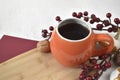 Close up autumn and winter still life scene. Cup of tea on tray, knitting scarf and red berries. Royalty Free Stock Photo