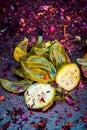 Close up of Ayurvedic face pack`s ingredients i.e cucumber and Aloe Vera gel with rose petals on a wooden surface in dark Gothic