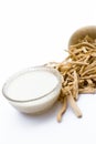 Close up of Ayurvedic herb Satavari or kurilo or Asparagus racemosus isolated on white in a glass bowl with milk.