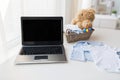 Close up of baby clothes, toys and laptop at home Royalty Free Stock Photo