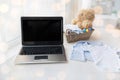 Close up of baby clothes, toys and laptop at home Royalty Free Stock Photo