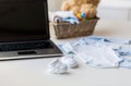 Close up of baby clothes, toys and laptop at home Royalty Free Stock Photo