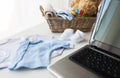 Close up of baby clothes, toys and laptop at home Royalty Free Stock Photo