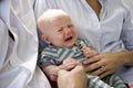 Close-up of baby crying in parents' arms Royalty Free Stock Photo