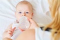 Close-up of baby eating food, water bottle. Mum feeds the child. Royalty Free Stock Photo