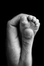 Close up baby feet in mother hands on black background. Prevention of flat feet Royalty Free Stock Photo