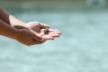 Close-up of baby frog on childs hand, blue water in background Royalty Free Stock Photo