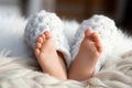 Close up of a baby girls legs, adorned with a gentle, white blanket