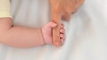 Close up baby hand holding finger mom in a room with a lot of sunlight. Newborn Royalty Free Stock Photo