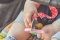 A close up of a baby hand holding a pacifier and a toy Royalty Free Stock Photo